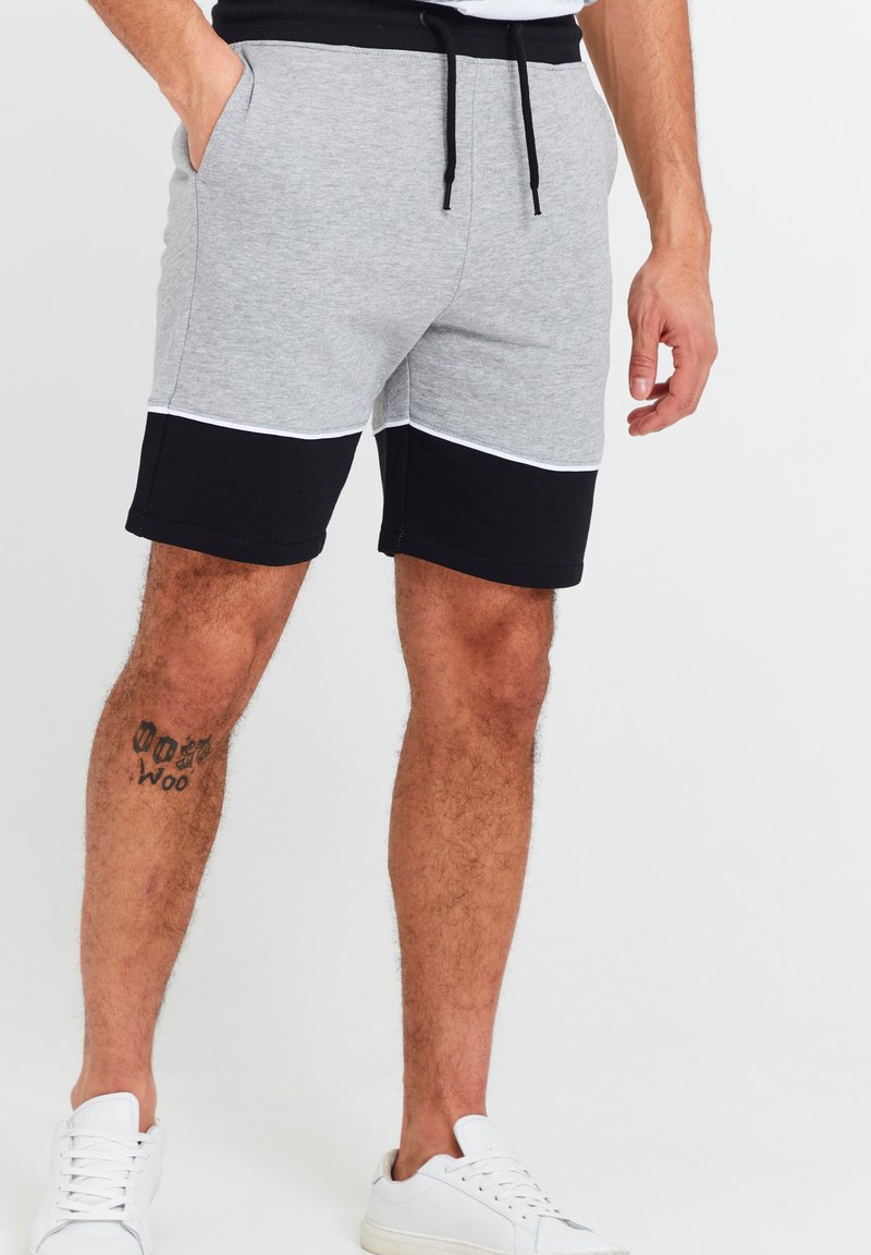 Grå og svart fargeblokkede treningsshorts i myk stoff, med elastisk midjebånd, snøring og sidelommer.