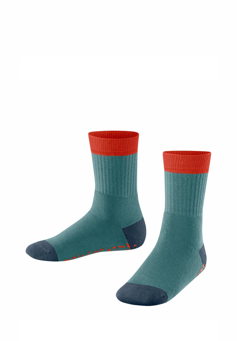Turkusowe skarpetki z czerwonym prążkowanym ściągaczem, ciemnoniebieską piętą i palcami, wykonane z fakturowanej tkaniny z jaskrawymi pomarańczowymi akcentami na podeszwie.