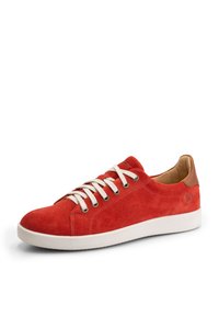 Baskets basses en daim rouge avec lacets blancs, semelle en caoutchouc blanche et accent en cuir marron clair sur le talon, vues de côté gauche sur fond blanc.
