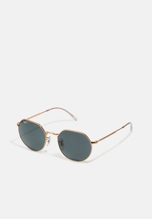 Occhiali da sole in metallo dorato con lenti scure ottagonali, dotati di sottili stanghette e morbidi supporti auricolari per il comfort. Logo distintivo su una lente.