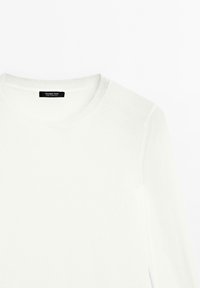Hvid langærmet t-shirt med rund hals og sort "Massimo Dutti" mærkat indvendigt i halsudskæringen, lagt fladt på en hvid baggrund.
