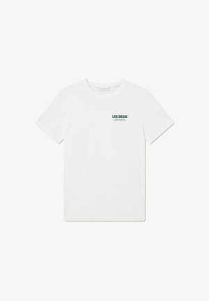 T-shirt en coton blanc avec un col rond, affichant un logo vert et du texte sur le côté gauche. Manches courtes, design simple, sans motifs.