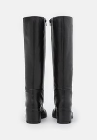 Czarne skórzane kozaki do kolan o gładkim wykończeniu, z bocznymi zamkami błyskawicznymi i grubymi, blokowymi obcasami. Posiadają detale przeszycia wzdłuż szwów.