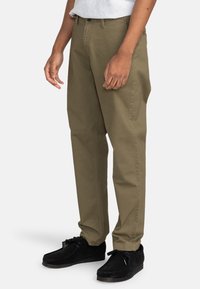 Kaki katoenen broek met een comfortabele pasvorm, voorzien van een rechte pijp, zakken en een knoopsluiting. Gemaakt met zwarte gestructureerde schoenen.