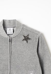 Felpa grigia con zip, con colletto a costine e ornamento a stella nera scintillante sulla spalla sinistra. Tessuto in morbido misto cotone.