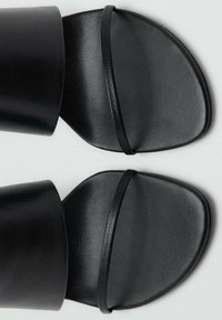 Sandali neri con suola piatta, ampie fasce opache e una banda stretta sulle dita, con una finitura testurizzata e una forma angolare.