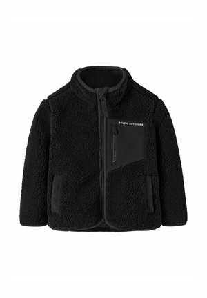 Veste polaire noire à fermeture éclair avec col haut, deux poches latérales et une poche poitrine zippée avec le texte "STUDIO OUTDOORS".