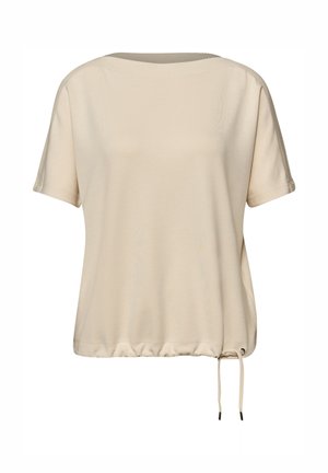 Haut ample à manches courtes beige avec encolure ronde et ourlet à cordon ajustable sur fond blanc.