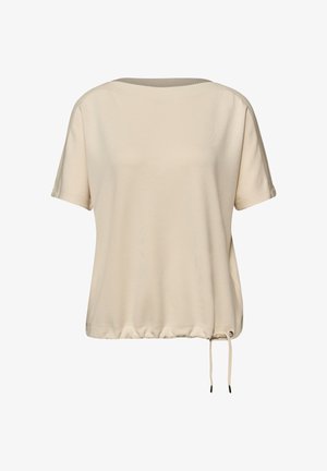 Beżowa luźna bluzka z krótkim rękawem, okrągłym dekoltem i regulowanym sznurkiem u dołu na białym tle.