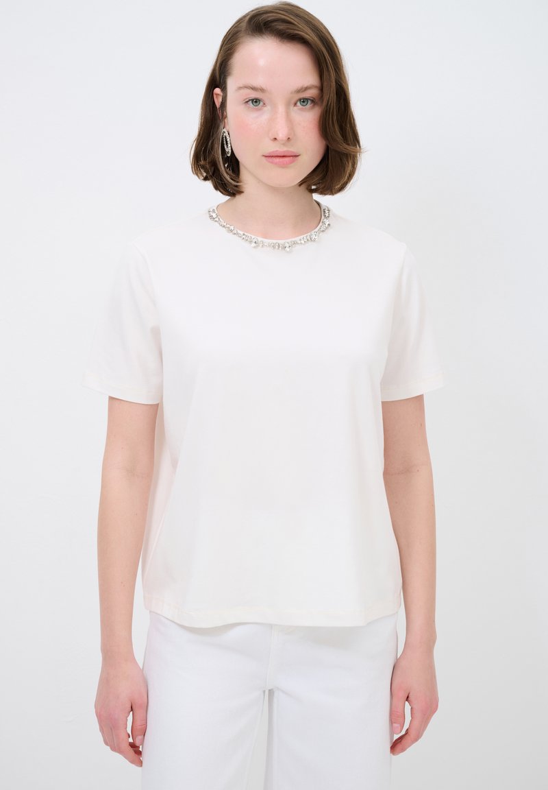 Witte t-shirt met korte mouwen en een ronde halslijn, voorzien van een decoratieve zilveren kra necklace aan de kraag. Gladde katoenstof.