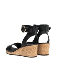 Czarne skórzane sandały na koturnie z plecioną juteową obcasem, z otwartym przodem, paskiem na kostkę i zapięciem z tyłu.