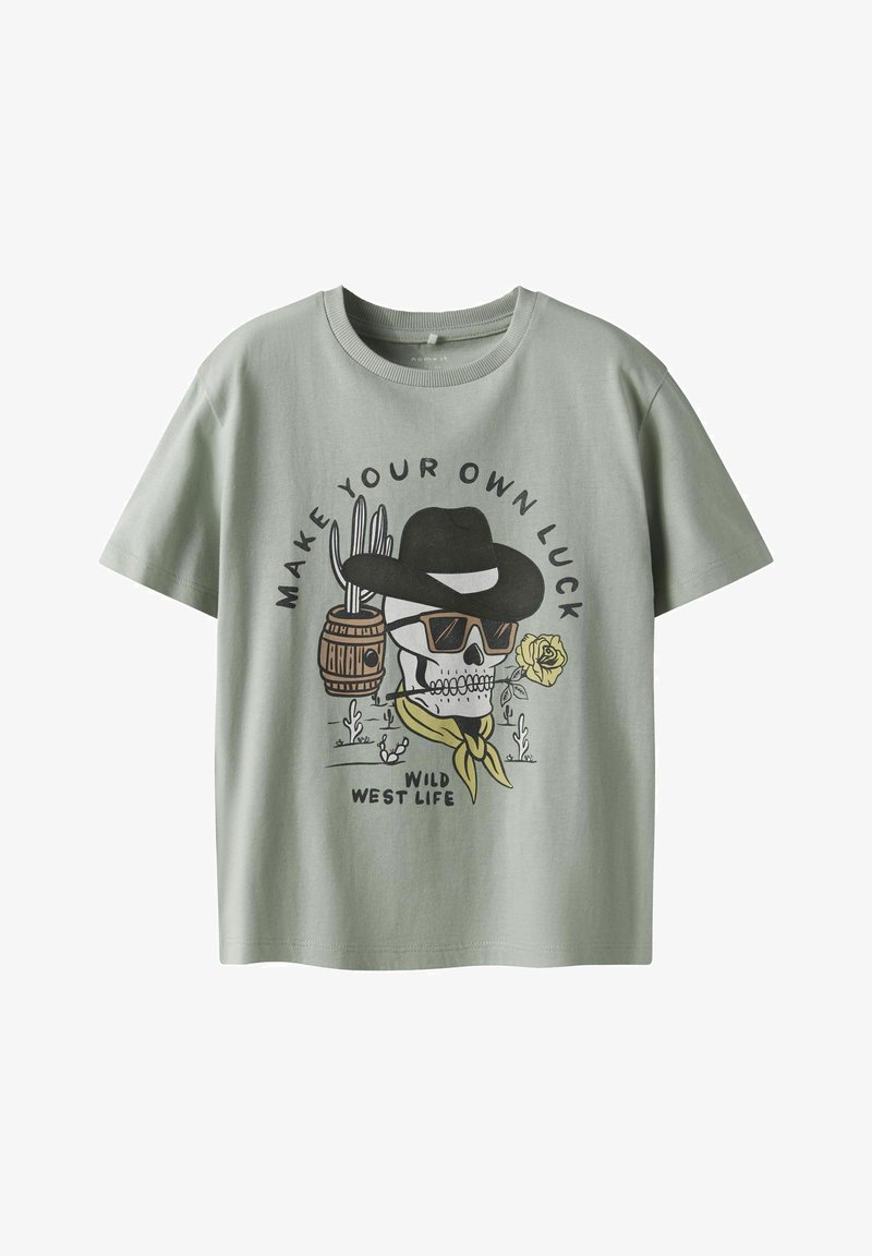Světle zelené tričko s krátkým rukávem vyrobené z bavlny, s potiskem designu lebky s kovbojským kloboukem a růží, obklopené dekorativními prvky.
