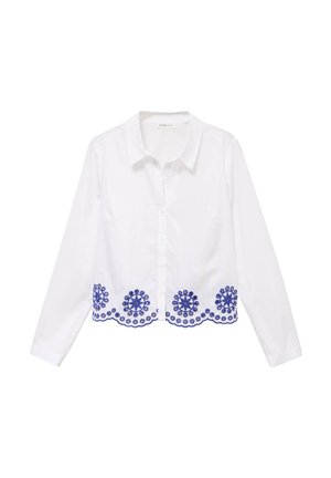 Hvid langærmet skjorte med knapper, krave og blå cirkulær blomsterbroderi langs den buede kant.