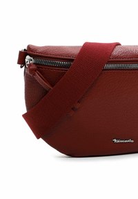 Borsa a spalla in pelle rossa con superficie testurizzata, cerniera argentata e tracolla in tessuto. Nome del brand "Tamaris" impresso.