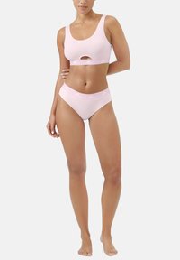 Ljusrosa sportbh med ett utskärningsdetalj och tjocka axelremmar, kombinerad med matchande höga underkläder med en logoband. Slät textur.
