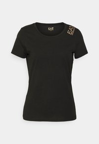 Svart kortärmad T-shirt i mjuk bomull, med rund halsringning och logotryck i guld på vänster axel. Ren design, inga mönster.