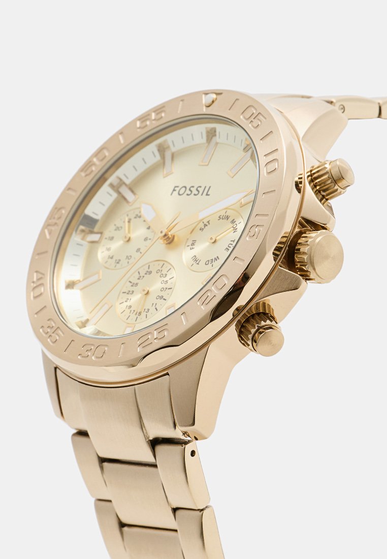 Orologio Fossil color oro con quadrante rotondo, tre sottoquadranti, ghiera texturizzata e cinturino in acciaio inossidabile con finitura lucida.