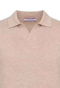 Pull polo beige en maille avec un col ouvert et une étiquette de marque Felix Hardy visible à l'intérieur de l'encolure.