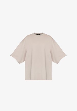 Przeciwny t-shirt z krótkim rękawem w jasnym beżu, wykonany z miękkiego materiału, z okrągłym dekoltem i opuszczonymi szwami barkowymi.