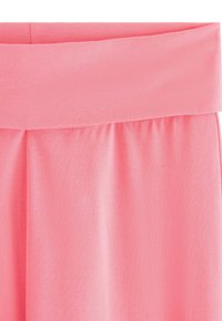 Soft pink fabric garment with a wide, folded waistband and gentle gathers below the waistline.