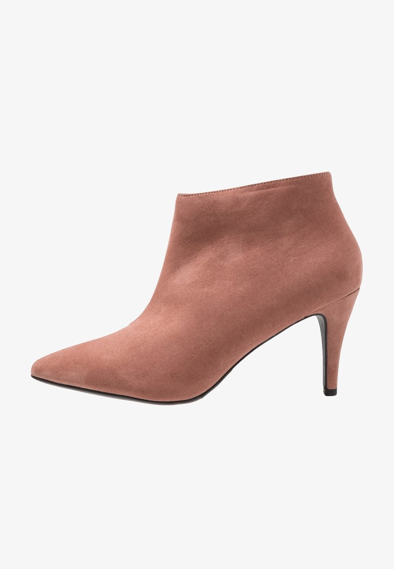 Botín de ante marrón hasta el tobillo con puntera puntiaguda y tacón delgado de altura media, mostrado en perfil lateral sobre un fondo blanco.