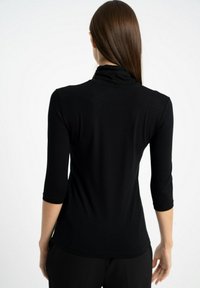 Czarny top z długim rękawem i golfem, wykonany z miękkiego materiału, dopasowany kształt oraz gładka, gładka tekstura.