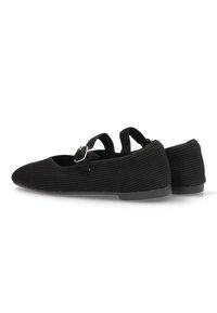 Zapatos de tela negra con superficie estriada, puntera redonda, suela plana y una correa con hebilla en el empeine.