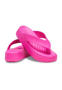 Roze flip-flops van rubberachtig materiaal, met een gladde textuur, een gecontoureerde zool en een minimalistisch ontwerp zonder zichtbare hardware.