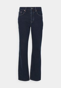 Mörkblå denim byxor med utsvängda ben, fem fickor, framknappstängning och kontrasterande sömmar. Slät textur med en lätt glans.