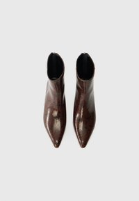 Botas de tornozelo de bico fino feitas de material com padrão de pele de cobra em tons de castanho e preto, com um design elegante e inserções laterais elásticas pretas.
