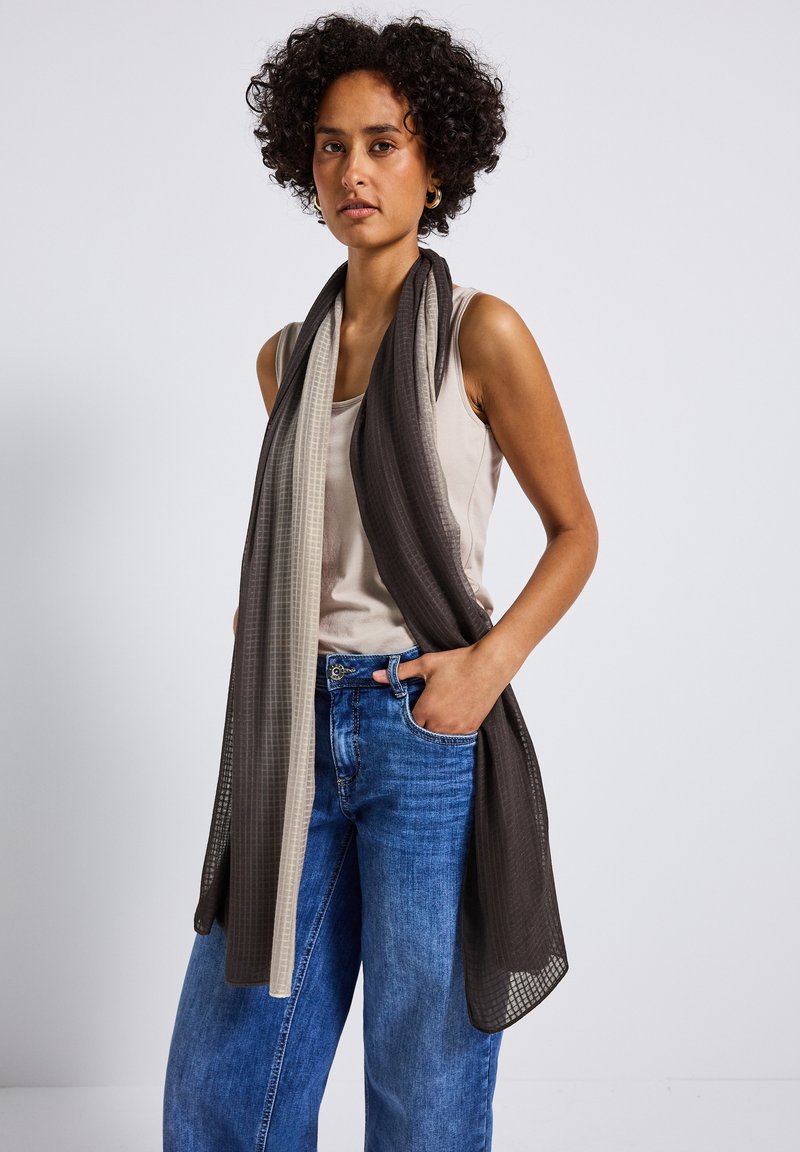 Lätt, mesh-scarf i växlande mörkgrå och beige paneler; har en mjuk textur och rundade kanter, hänger elegant.