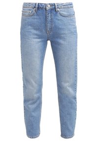 Ljust blå denimjeans med hög midja, rak bendesign och subtila blekningar. Har en framsittande knappstängning och fem fickor.