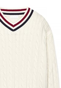 Suéter de punto trenzado en crema con escote en V. Presenta un cuello a rayas en rojo, blanco y azul marino. Patrón de punto texturizado en toda la prenda.