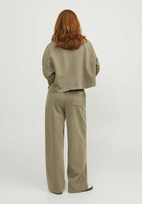 Olijfgroene cropped sweatshirt met een losse pasvorm, gecombineerd met bijpassende wijde broek met een achterzak en een zachte textuur.