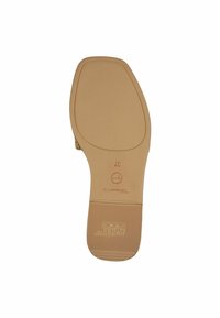Beige skosula med texturerad yta, lätt båge och varumärkeslogotyp. Har cirkulär ikon och storleksangivelse (37) tryckt på undersidan.