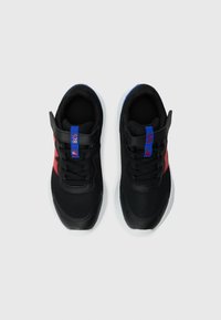 Chaussures de sport noires avec une tige en mesh, accents rouges et bleus, et une semelle blanche contrastante. Présentent des sangles réglables et un design texturé.