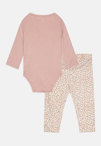 Rosa Langarm-Body kombiniert mit crèmefarbenen Leggings, die ein kleines Blumenmuster in Orange, Blau und Grün aufweisen. Aus weich flexibler Baumwolle.