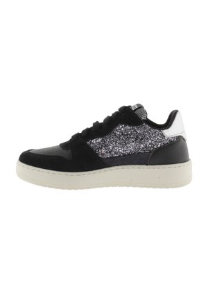 Zapatilla negra con acentos plateados brillantes. Presenta texturas de ante y cuero, punta redonda, diseño de cordones y una suela de goma color crema.