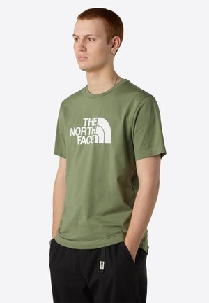 Olijfgroen katoenen t-shirt met een groot wit "The North Face" logo, ronde halslijn, korte mouwen en een relaxte pasvorm.