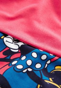 Tessuto di cotone con uno strato superiore rosa uniforme sovrapposto a un tessuto blu decorato con pois e dettagli di personaggi dei cartoni.