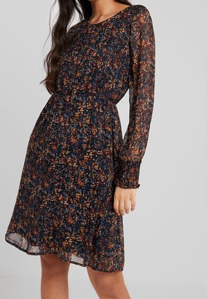 Dark floral dress made of lightweight fabric with long sleeves and a gathered waist, featuring a multicolored floral pattern on a navy background.