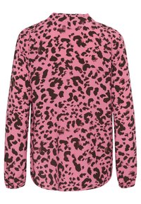 Rosa skjorta med ett svart leopardmönster, långa ärmar och rak nederkant. Tyget verkar slätt med en lätt glans.