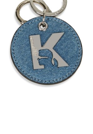 Denim keychain with a circular shape, featuring a shiny silver 'K' logo and a textured denim surface. Attached to a metallic keyring.
