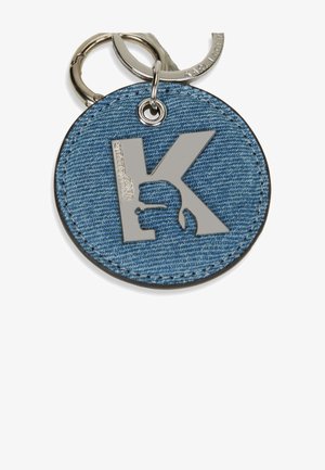 Denim keychain with a circular shape, featuring a shiny silver 'K' logo and a textured denim surface. Attached to a metallic keyring.