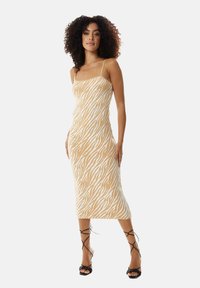Knit midi dress with a fitted silhouette, featuring a beige base and white zebra stripes, thin straps, and a smooth texture.