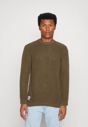 Maglione verde lavorato a maglia con un design a coste, scollatura rotonda, maniche lunghe e spacchi laterali. Etichetta visibile all'orlo sinistro.