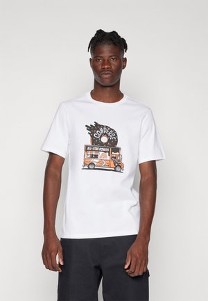 Camiseta blanca de algodón con un estampado gráfico de un camión de comida naranja que dice "All-Star Donuts" y un diseño salpicado encima.