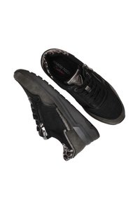 Schwarze Wildleder-Sneaker mit einem strukturierten grauen Akzent, ausgestattet mit einem seitlichen Reißverschluss, Schnürdesign und Futter im Leopardenmuster. Dicke Gummisohle.