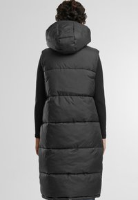 Langer schwarzer Puffer-Westenmantel mit großer Kapuze, ausgestattet mit horizontalen Steppnähten und einer glatten, glänzenden Textur. Reicht bis unter die Knie.