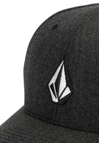 Casquette noire en tissu texturé avec un logo brodé blanc. Le design comprend une visière incurvée et des détails cousus.